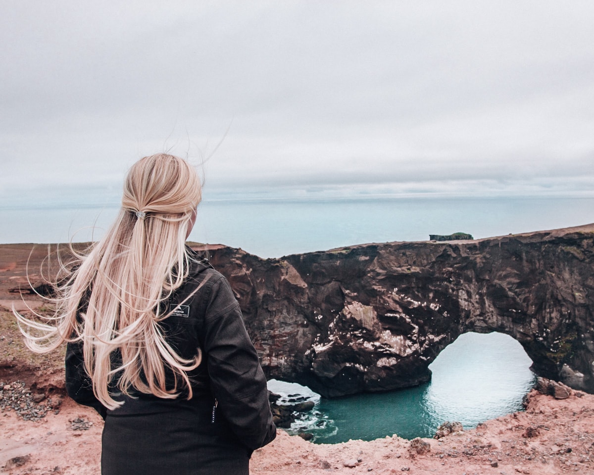 Looking out at the black rock arch from the Dyrholaey lighthouse near Vik in Iceland. Check out our perfect 6 day itinerary for Ring Road in Iceland!