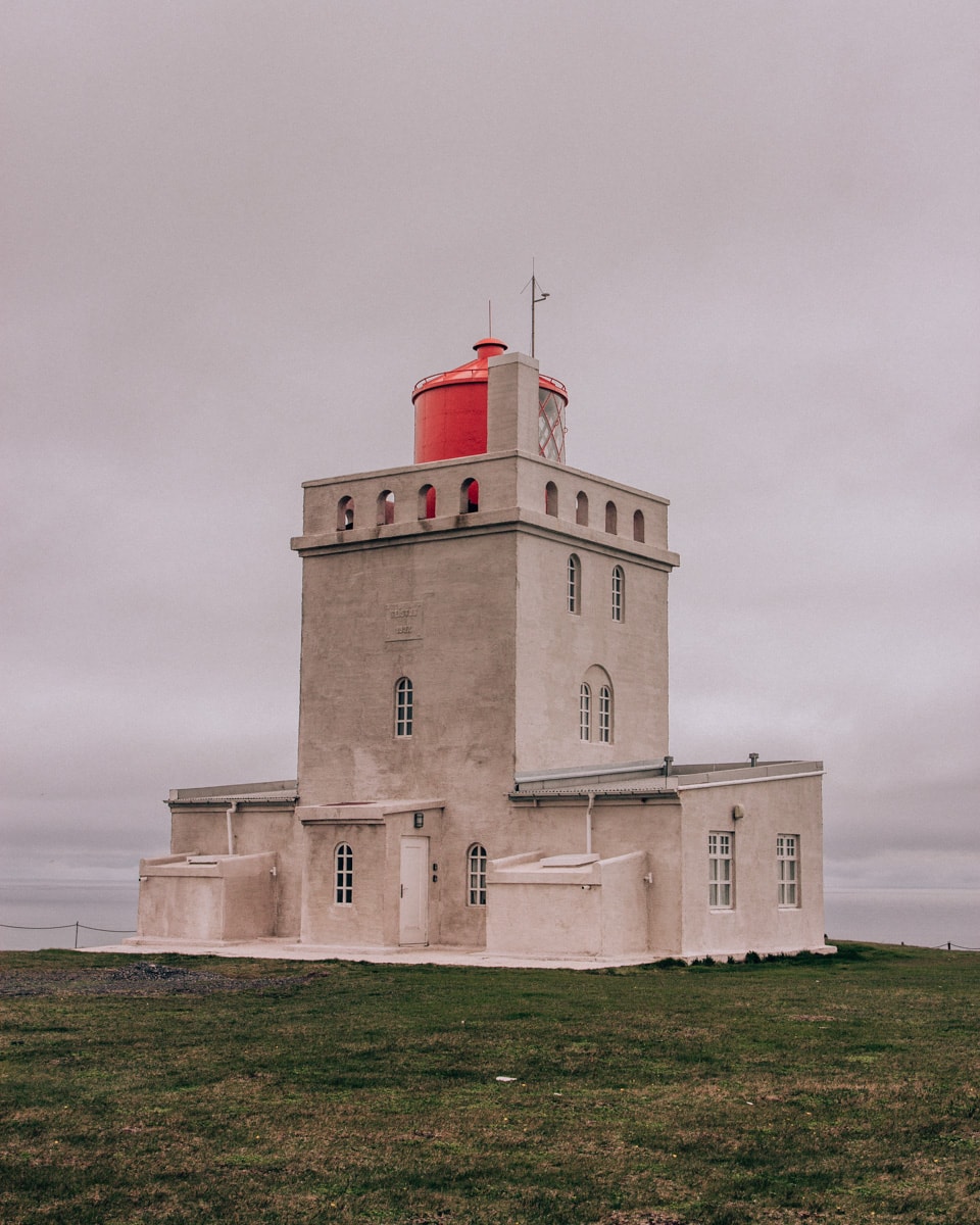 Dyrholaey's lighthouse near Vik and Reynisfajara in Iceland. Get our full 6 day Iceland itinerary for the ultimate Iceland road trip around Ring Road.