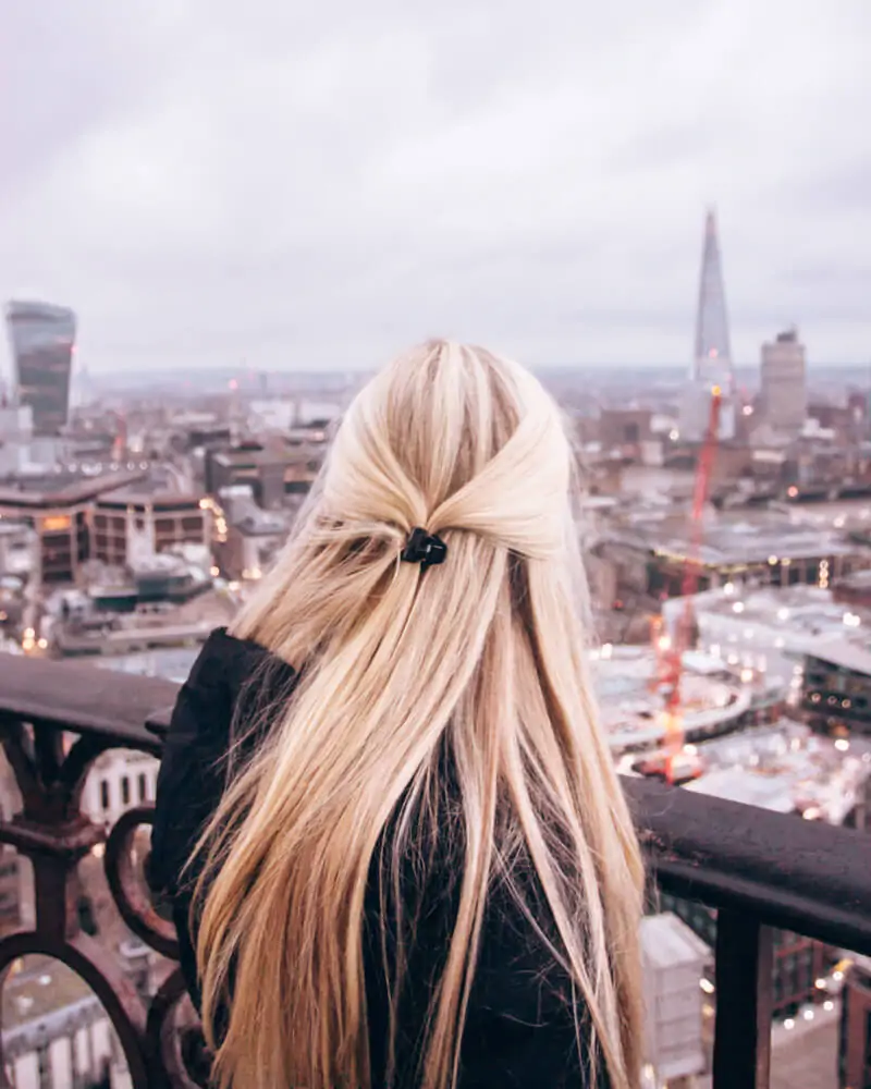 Blonde woman at the top of St. Paul's Cathedral's dome near sunset. Get a full 3 day London itinerary with all the best Instagram photo spots in London here.