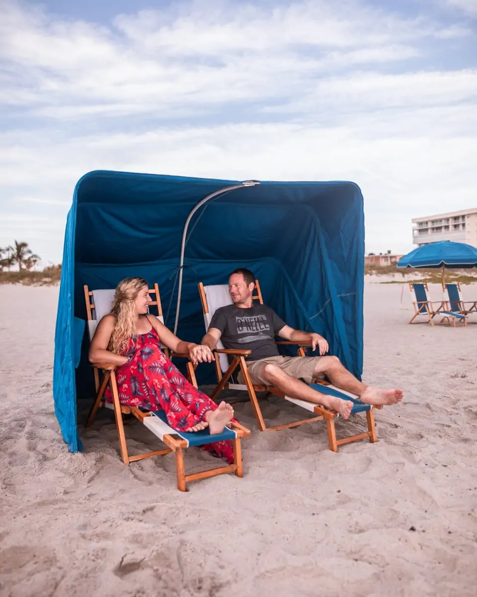 A couple relaxes in a beach cabana on Cocoa Beach at Westgate Cocoa Beach Resort in Florida.