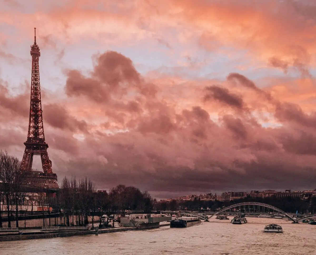Sunset in Paris with the Eiffel Tower and the Seine River. Find the best views of the Eiffel tower and how to celebrate New Year's in Paris here.