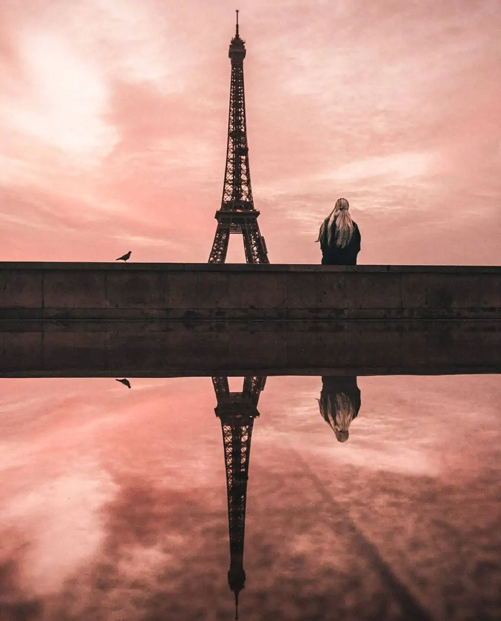 Trocadero view of Eiffel Tower at sunrise with a reflection in a puddle. Get all the best Eiffel Tower views and a guide to New Year's in Paris here.
