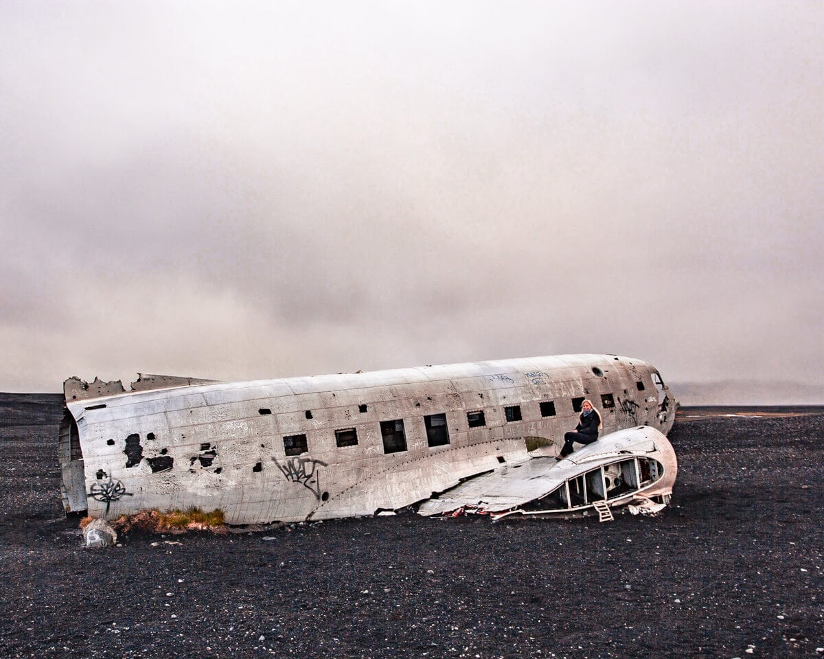 A woman sitting on the famous Iceland airplane crash