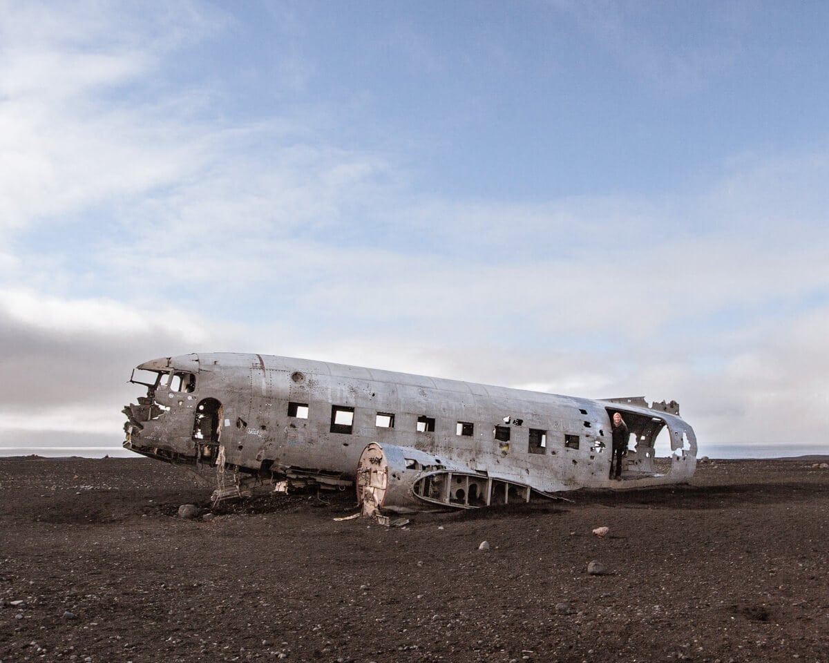 A woman standing in the doorway of the Sólheimasandur plane crash in Iceland