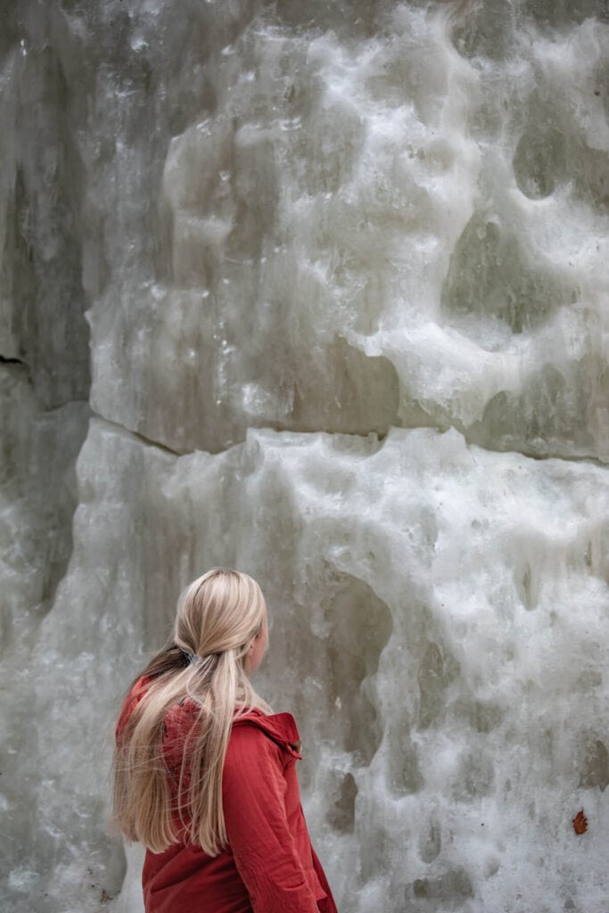 woman standing by frozen block of ice at champney falls