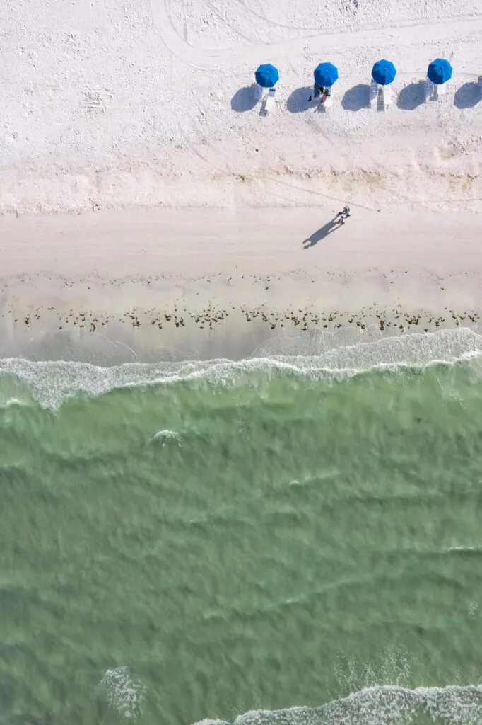 Drone shot of beach umbrellas and a couple on Fort Myers Beach