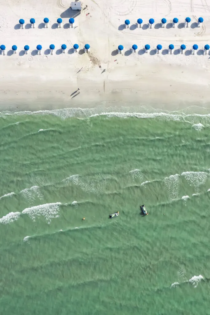 drone shot of fort myers beach with umbrellas and jet skis