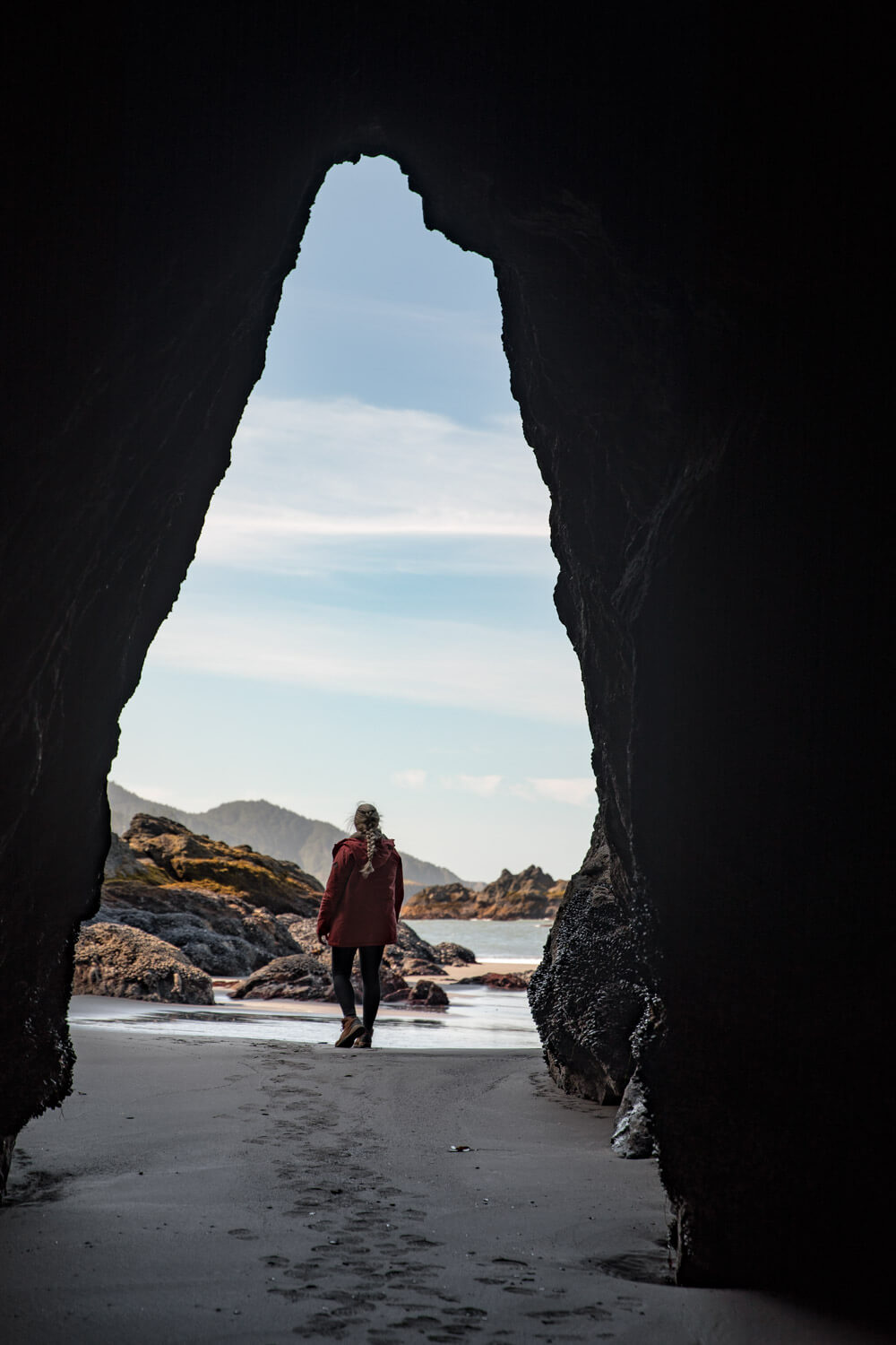 woman in secret beach sea cave in oregon