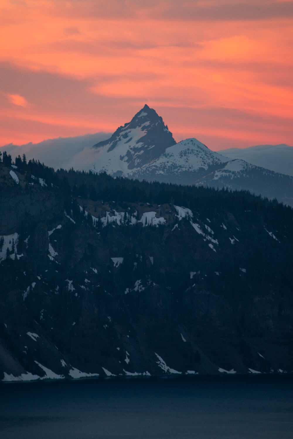 mount thielsen with pink clouds behind it at sunset from crater lake