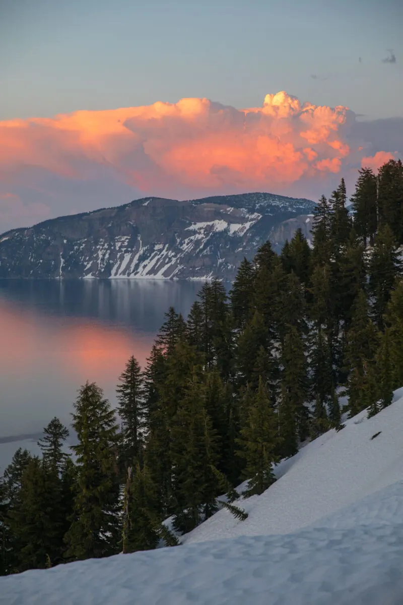 crater lake at sunrise with a thunderhead