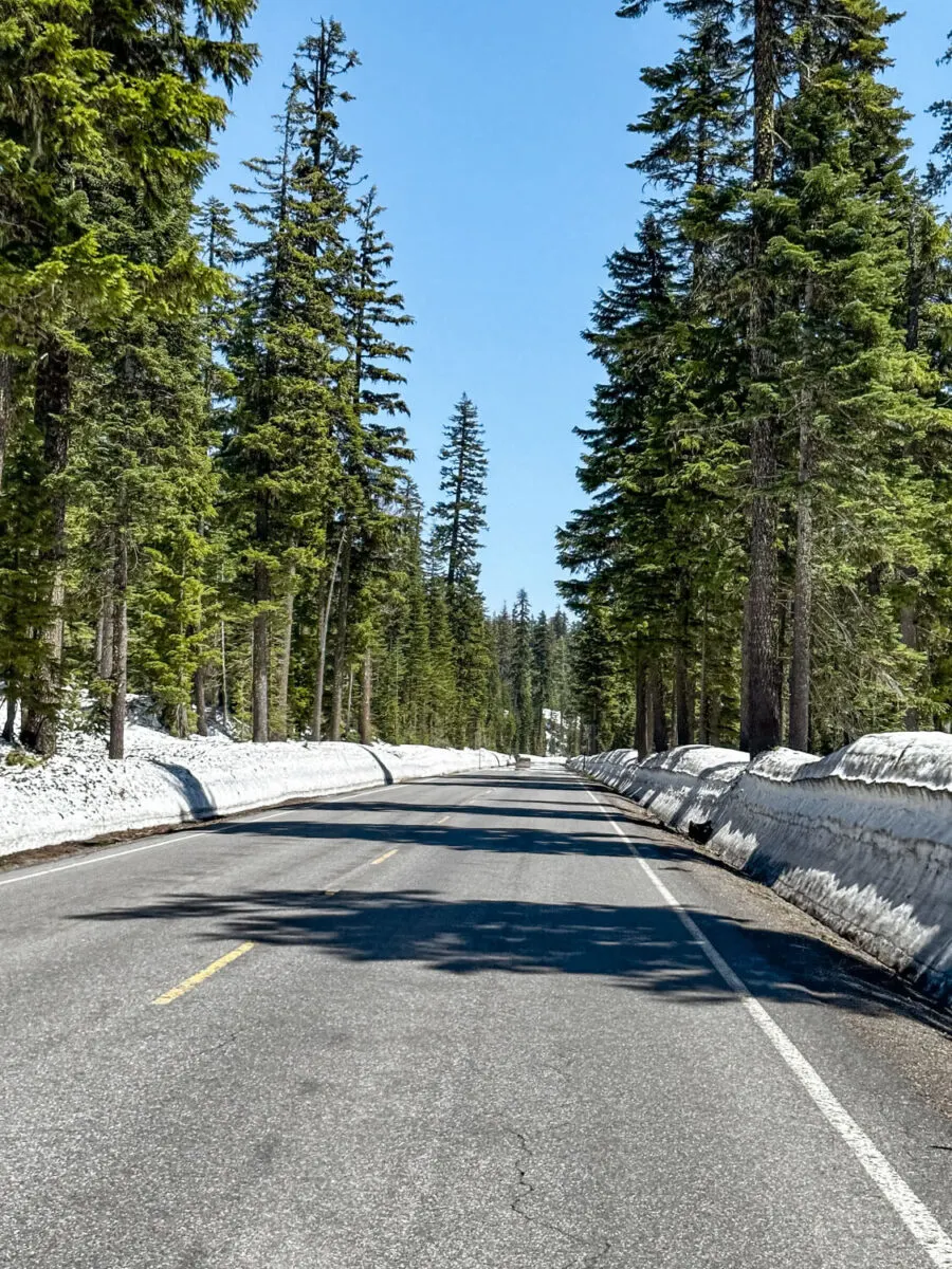 snow piled up on the sides of the road going into crater lake national park in may