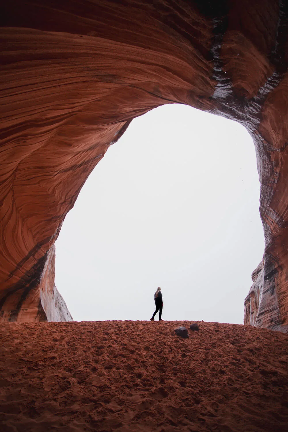 woman standing on the sand dune in the page sand cave on a rainy day