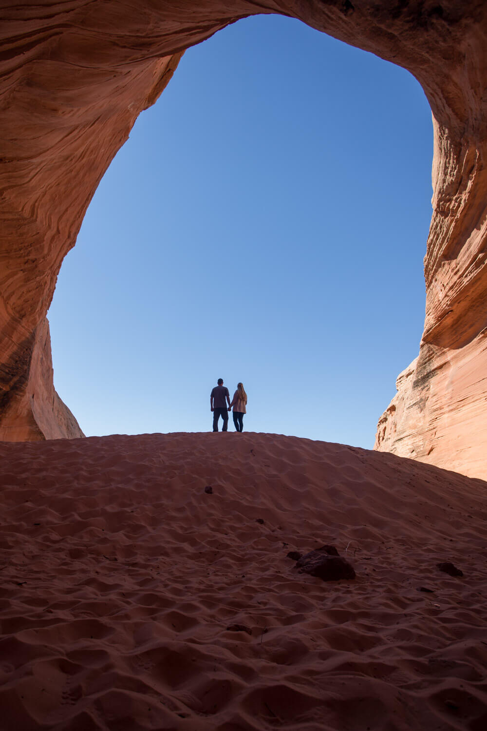 a couple standing on the sand dune in the big lake sand cave in page arizona